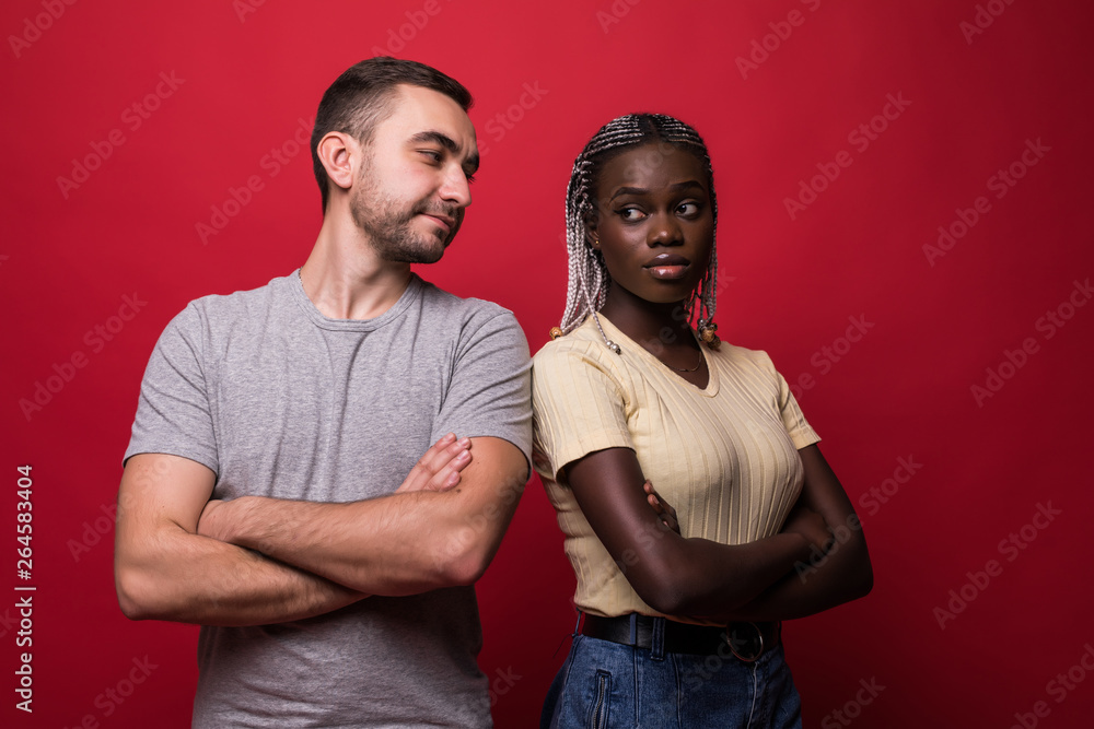 Obraz premium Young mixed race couple having a quarrel isolated on red background