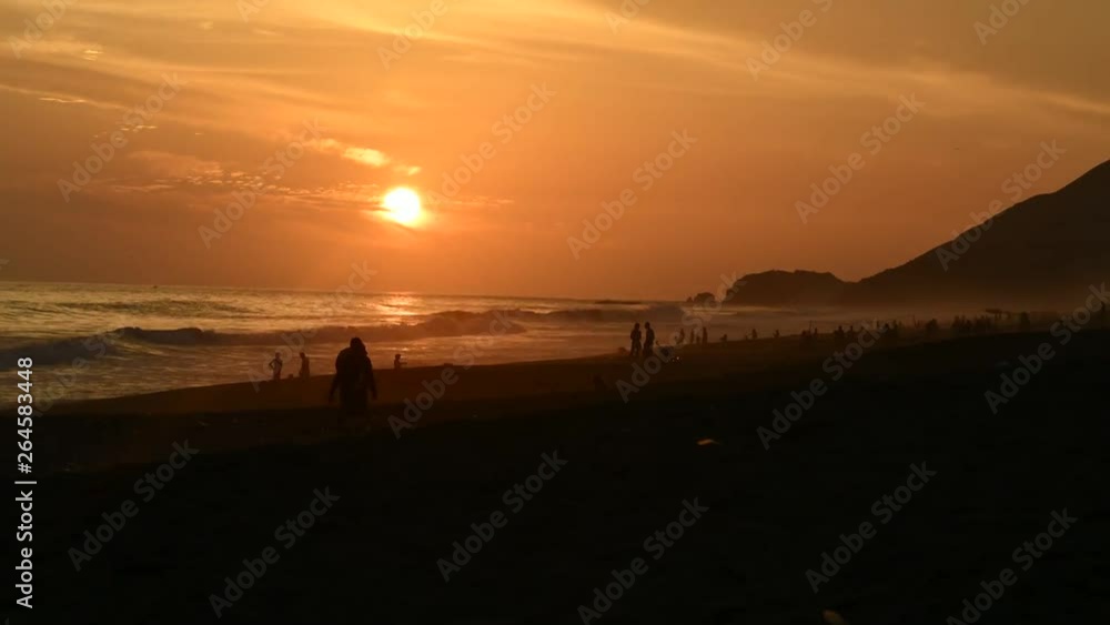 Beautiful beach timelapse in Lima, the sun sets next to a mountain along the beach