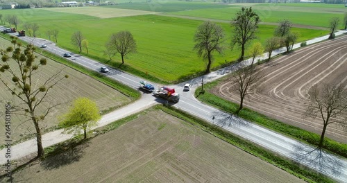 Drone shot of traffic on x shaped crossroad on countryside. Driving cars, trucks, buses on intersection. photo