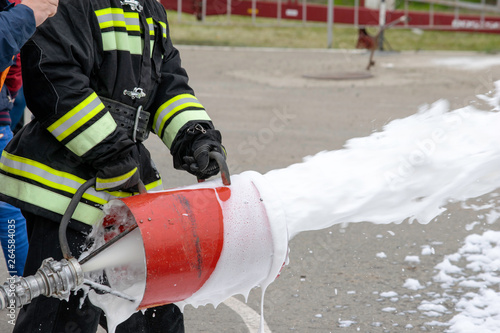 Supply of foam from a foam generator, fire extinguishing foam flies from the foam generator, which keeps the fireman in combat clothing photo