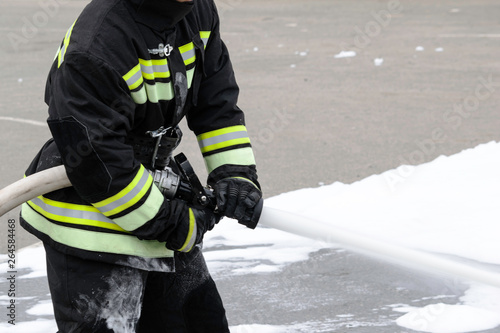 Feeding foam from a handheld fire fighter, fire extinguishing foam flies out of the trunk, which keeps the fireman in combat clothing