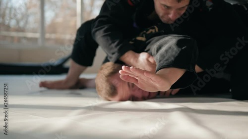 Concept of defeat, loss. Martial artist hand wearing mix mma open fingers gloves touching the tatami gym mats resembling tiredness, defeat, fatigue, exhaustion surrender surrend jiu jitsu boxing. photo
