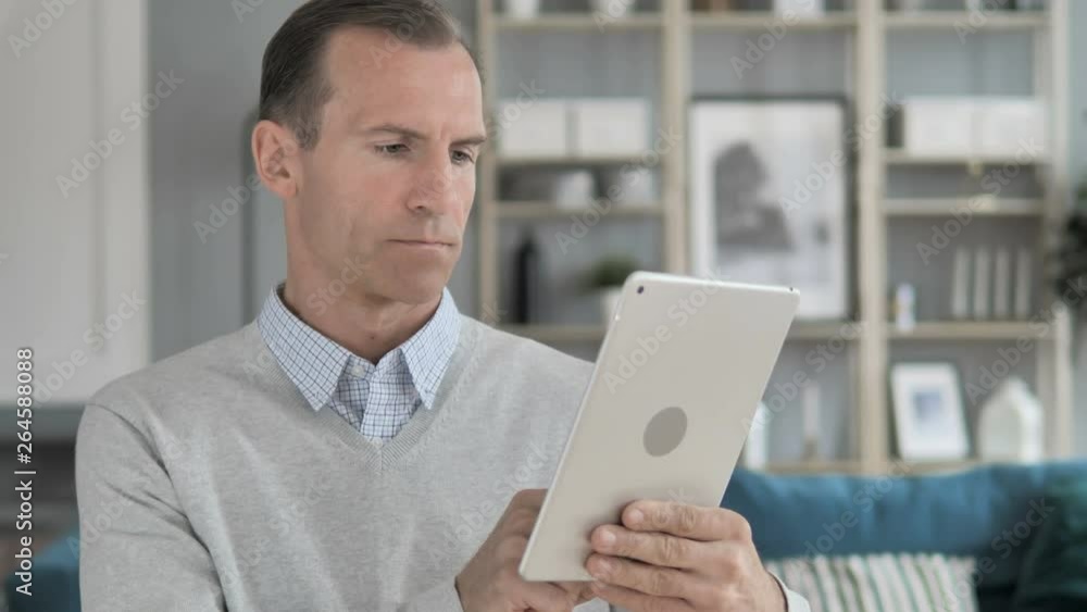 Middle Aged Man Browsing on Tablet Middle Aged Man Browsing on Tablet