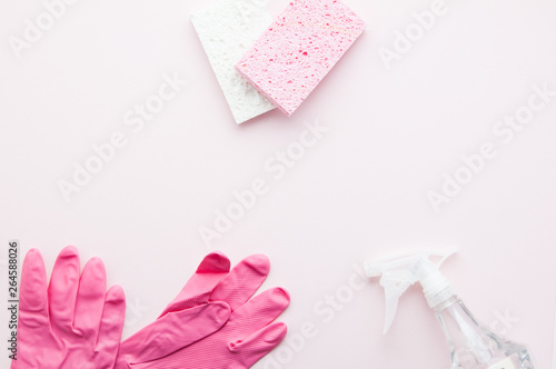 spring cleaning supplies on a pink background with copy space