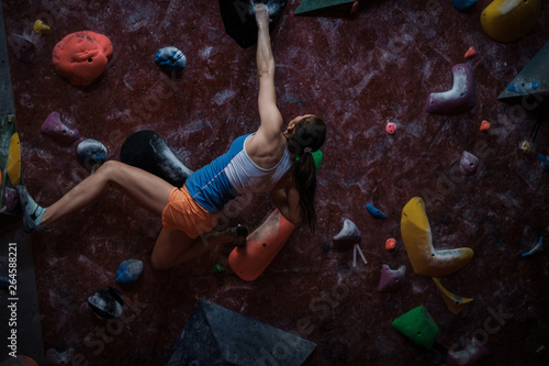 Athletic woman practicing in a bouldering gym