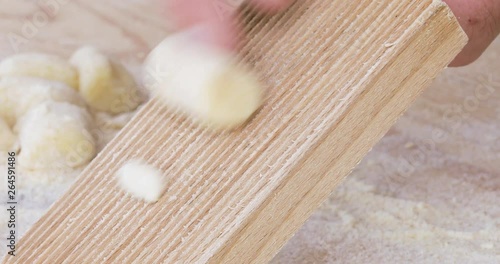 Mani di un uomo che fanno la preparazione degli gnocchi di patate fati in casa con rigagnocchi e tagliere in legno. photo