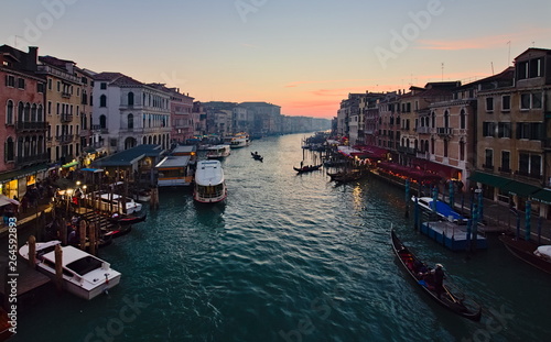 Venice, Italy - December 29, 2018: Sunset view from Ponte Di Rialto on the Grand Canal, with boats and gondolas