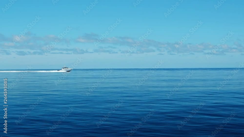 A speedboat rides over the Indian Ocean while the sun is shining A speedboat rides over the Indian Ocean while the sun is shining