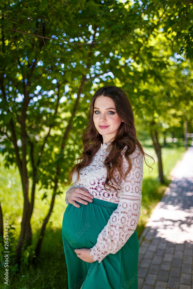 portrait of young pregnant woman in park portrait of young pregnant woman in park