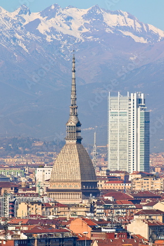Aerial panoramic view on Turin city center with Mole Antonelliana  modern skyscraper and other buildings  clear blue sky morning with Alps on background