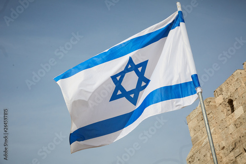 flag of Israel against the sky and the wall photo