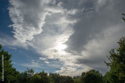 Blue sky with dramatic clouds in direct sun light on a spring afternoon in Issy-les-Moulineaux, France