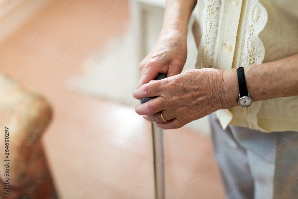 Close-up of senior's hand leaning on cane