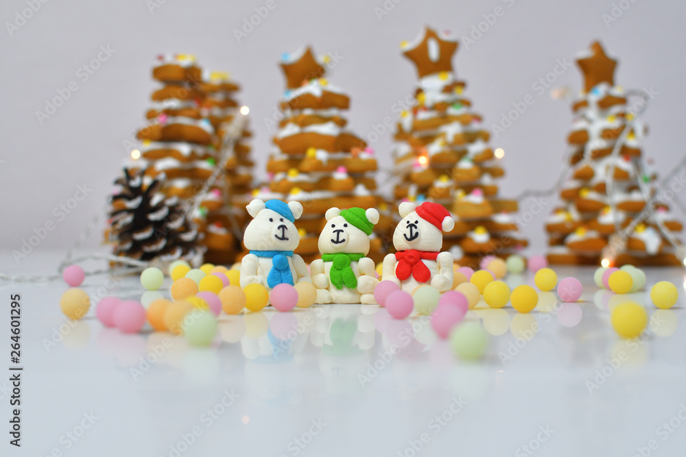 gingerbread Christmas tree.Christmas Gingerbread cookie with multi-colors caramel.Sugar white bears in red hat on white background next to multi-colors caramel gingerbread Christmas tree.Christmas Gingerbread cookie with multi-colors caramel.Sugar white bears in red hat on white background next to multi-colors caramel