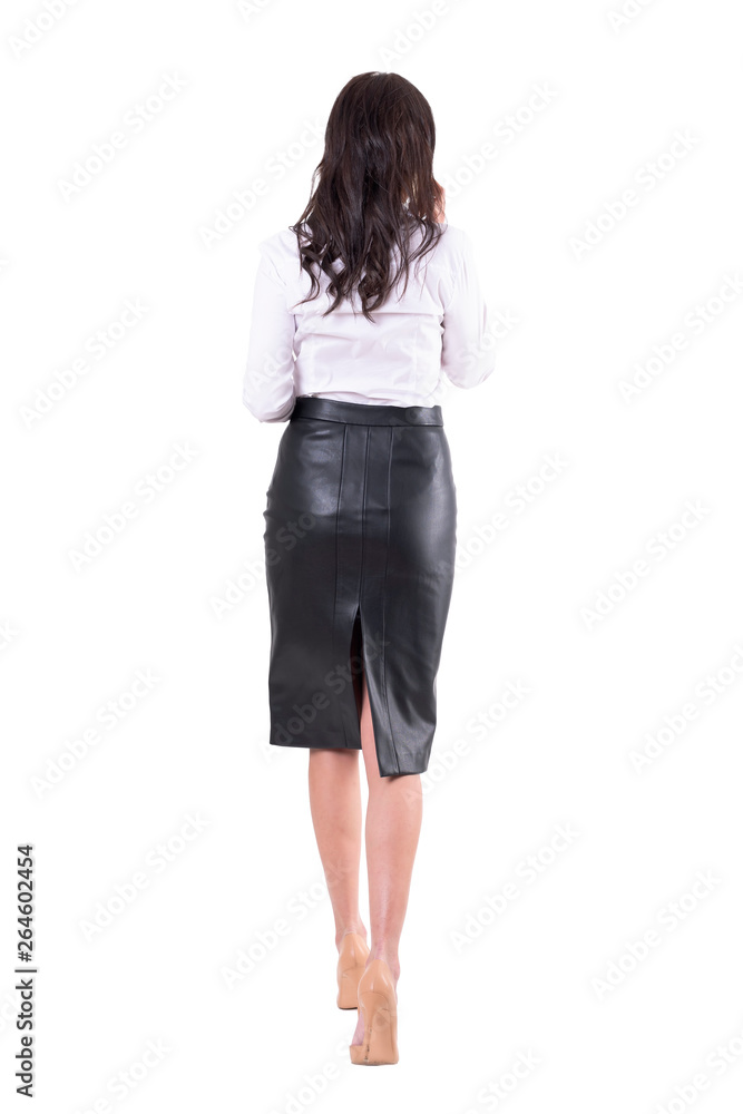Rear view of elegant business woman walking away talking on the cellphone. Full body isolated on white background. Rear view of elegant business woman walking away talking on the cellphone. Full body isolated on white background.