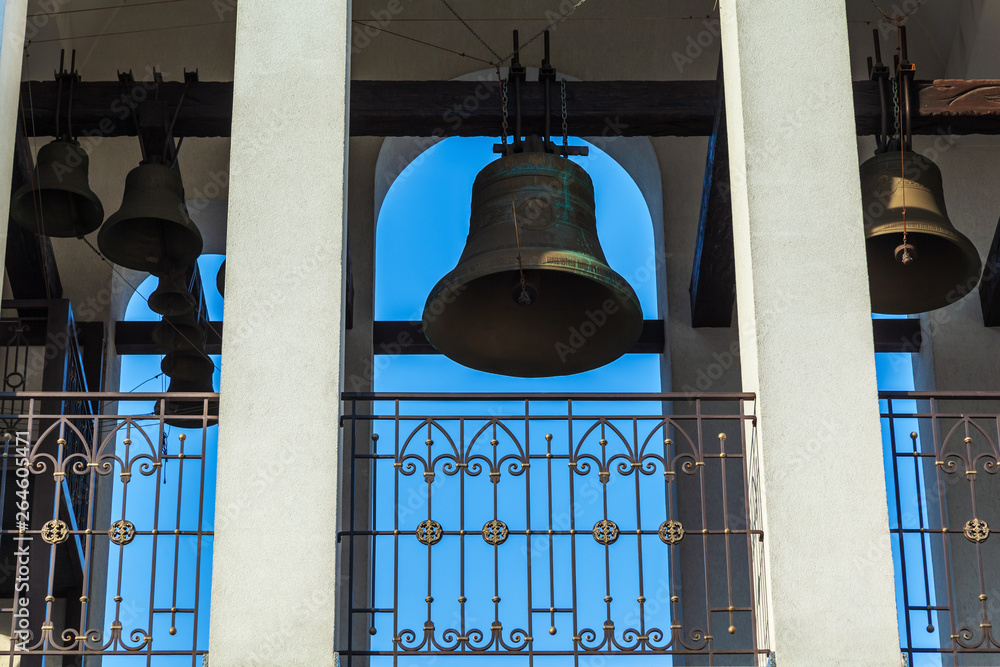 Obraz premium Big copper bell on the belfry of the bell tower of a Christian church temple at Easter.
