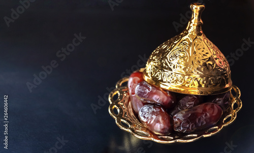 Photography Golden plate with dried date palm fruits or kurma