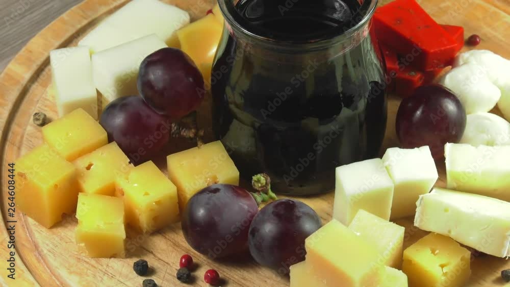 Cheese plate close-up with several varieties of fruit and honey cheese.