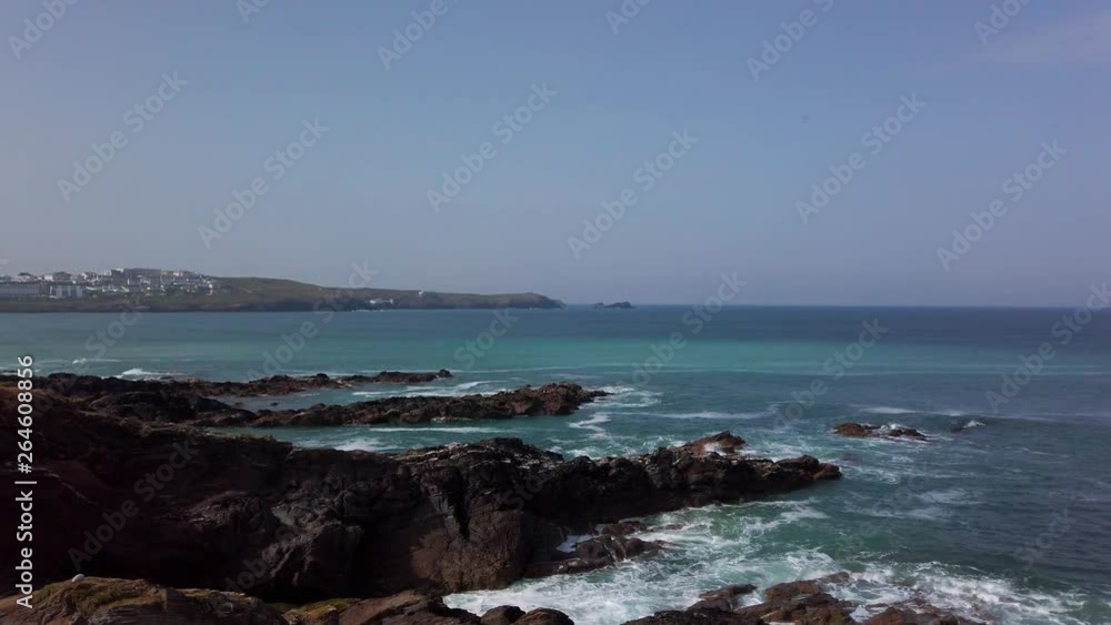 Newquay coastline in Cornwall, UK with waves crashing into rocks Newquay coastline in Cornwall, UK with waves crashing into rocks