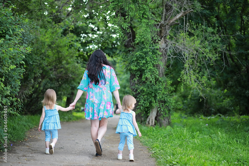 Fototapeta premium Mom with two daughters twins