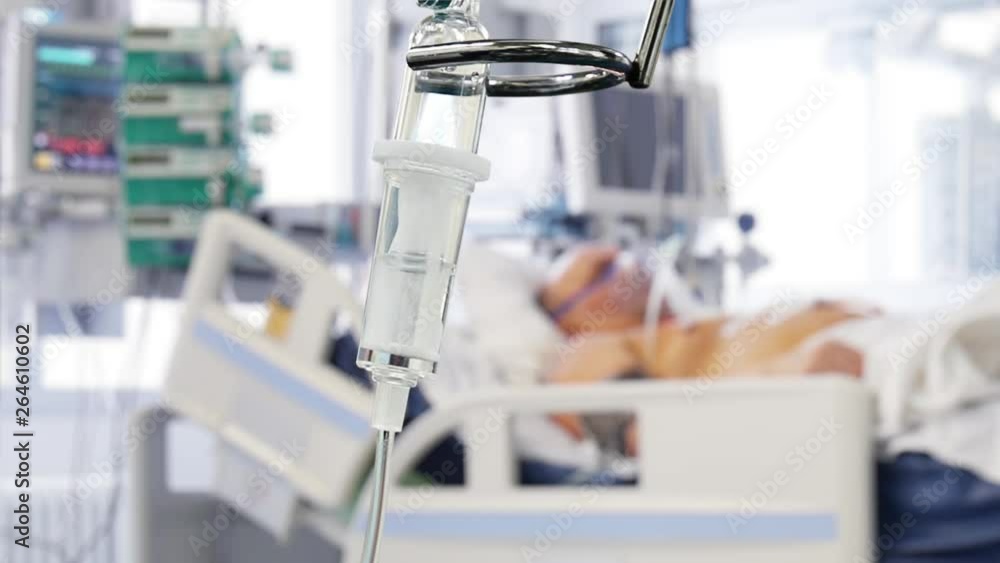 Intravenous Dropper with Patient on the Background in the Hospital Intravenous Dropper with Patient on the Background in the Hospital