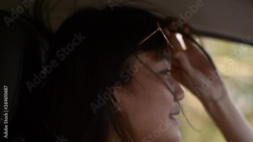 asian lady smiling and put sunglasses up while driving in vacation