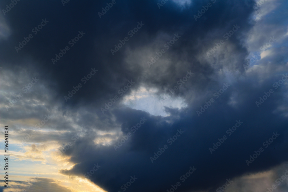 Obraz premium Blue sky with gold clouds - dramatic sunset, beautiful natural background. Setting sun illuminates the clouds.