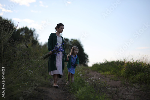 Mother with daughter walking on a road