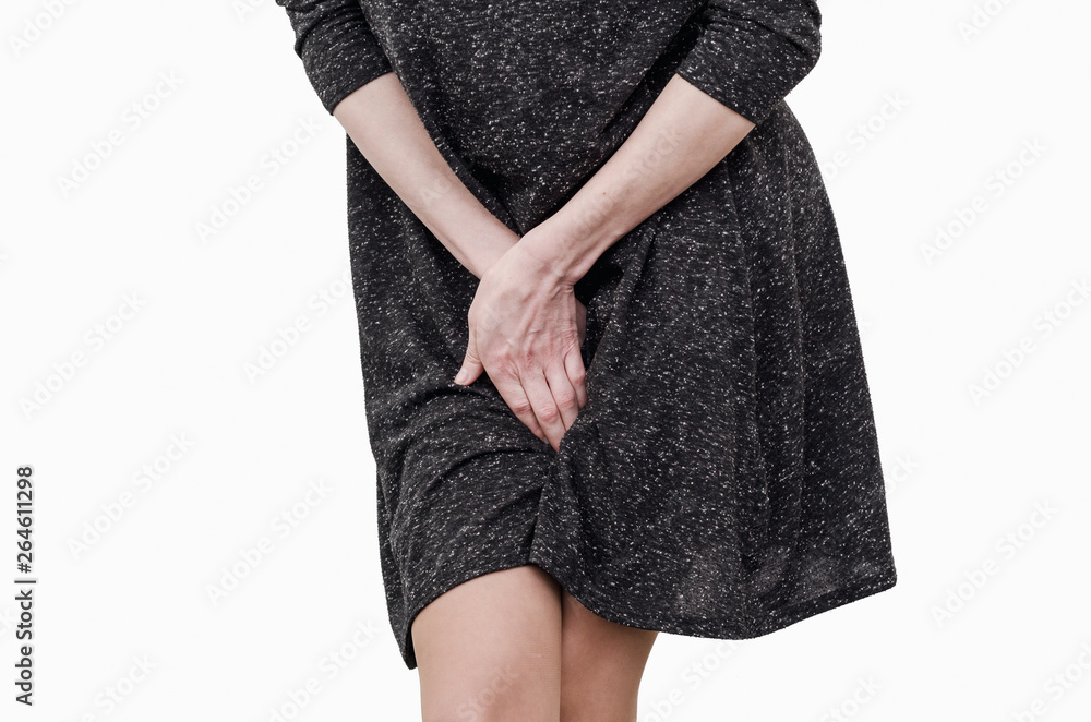 Slender girl in a dark dress experiences discomfort in the uterus, pain,  hands between her legs. Incontinence, need to pee in the toilet Stock Photo  | Adobe Stock