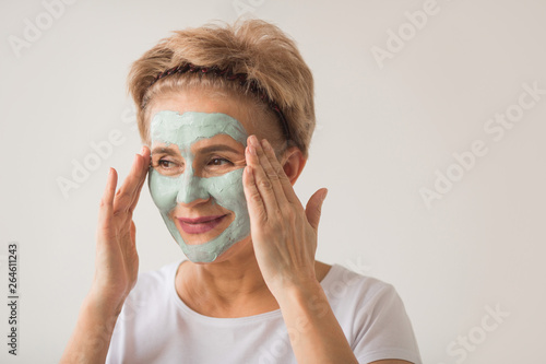 beautiful elderly woman with a wellness cream face mask