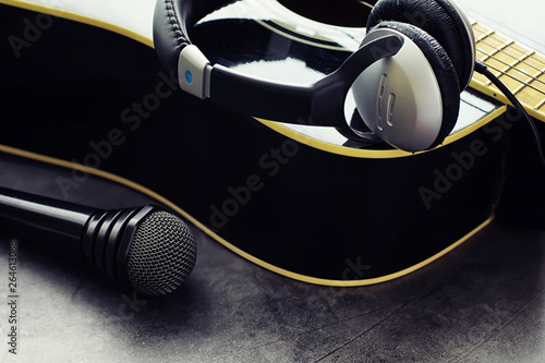 Guitar and accessories on a stone background. Desk musician, headphones, microphone. photo