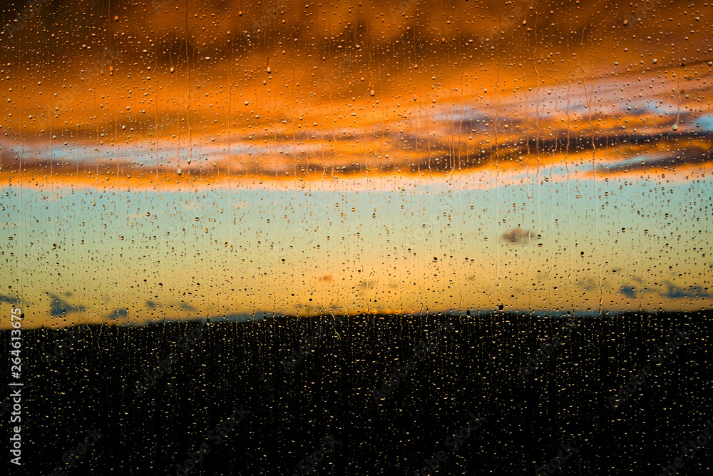 sunset under the rain through the window