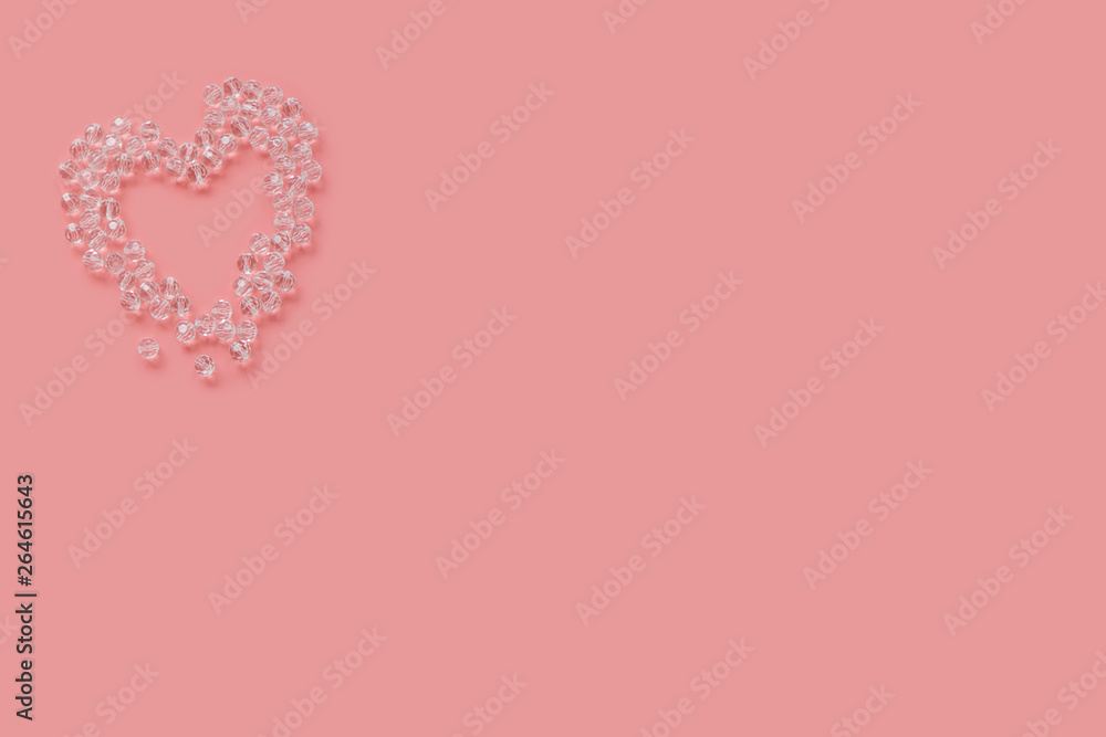Beautiful pink background with heart made of crystal beads for your text and design. space for labels. The view from the top. Layout. Minimum.
