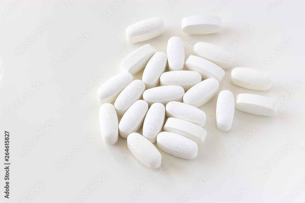 Close up white Calcium carbonate or Vitamin and mineral pills tablets isolated on white background. Close up white Calcium carbonate or Vitamin and mineral pills tablets isolated on white background.