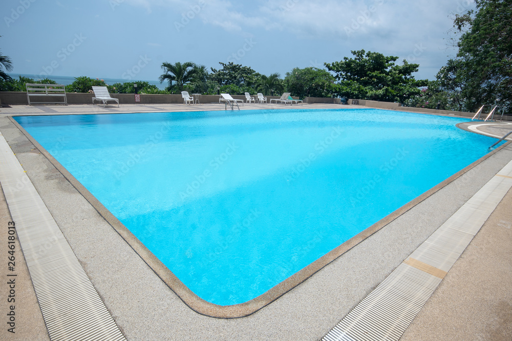 Large rectangular swimming pool against the background of the ocean at the seaside.