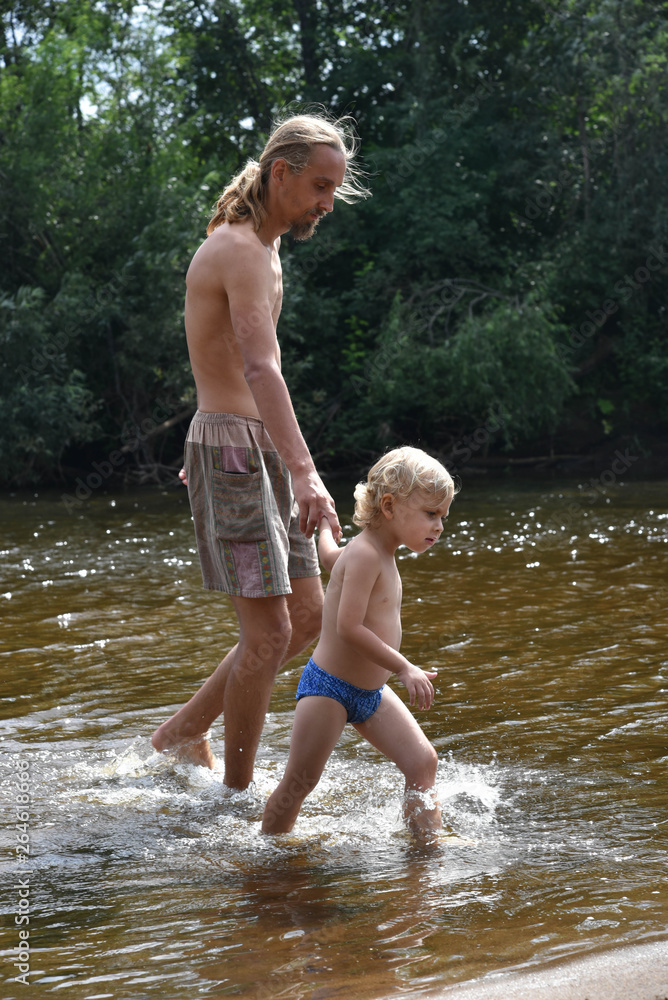 Father and son on the beach. Happy family. river. Father and son on the beach. Happy family. river.