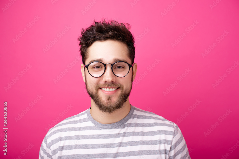 Obraz premium Portrait of handsome smiling man with glasses, over pink isolated background
