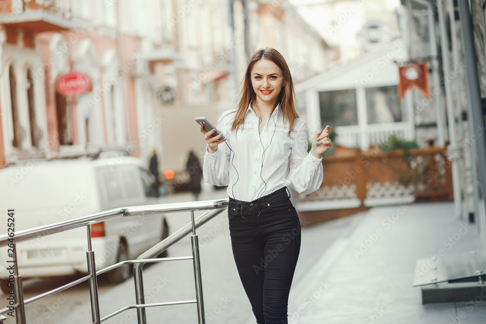 The girl walks around the city. Girl with phone. The girl is outdoors The girl walks around the city. Girl with phone. The girl is outdoors