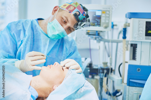 Several doctors surrounding patient on operation table during their work. Team surgeons at work in operating room