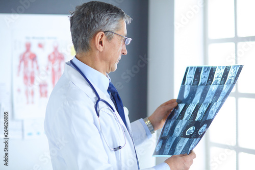 Doctor in the office examines the patient's x-ray photo