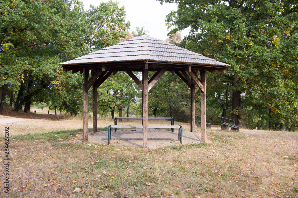 Simplicity wooden shelter with seats in nature, small gazebo for tired tourists Simplicity wooden shelter with seats in nature, small gazebo for tired tourists