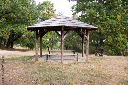 Simplicity wooden shelter with seats in nature, small gazebo for tired tourists