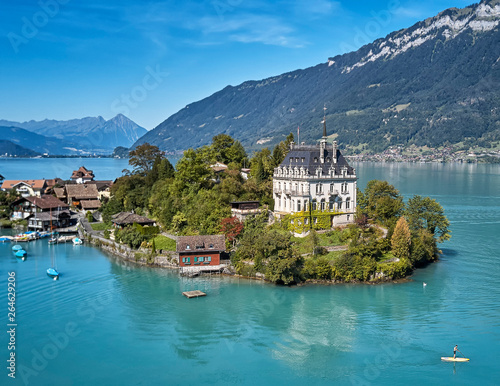 Castle on small island surrounded by azure blue water on the Brienzersee in Switzerland photo
