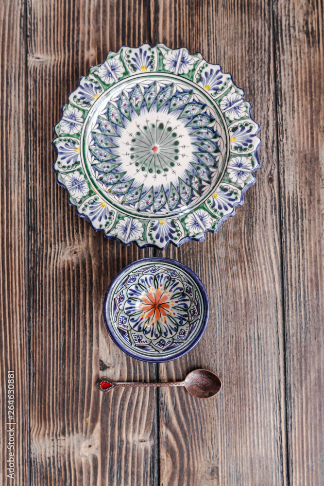 Authentic middle east style plate, bowl and a bronze spoon on the wooden desk. Flat lay, top view. Vertical orientation. Authentic middle east style plate, bowl and a bronze spoon on the wooden desk. Flat lay, top view. Vertical orientation.