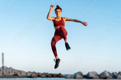 Sportive young woman during workout, jumping