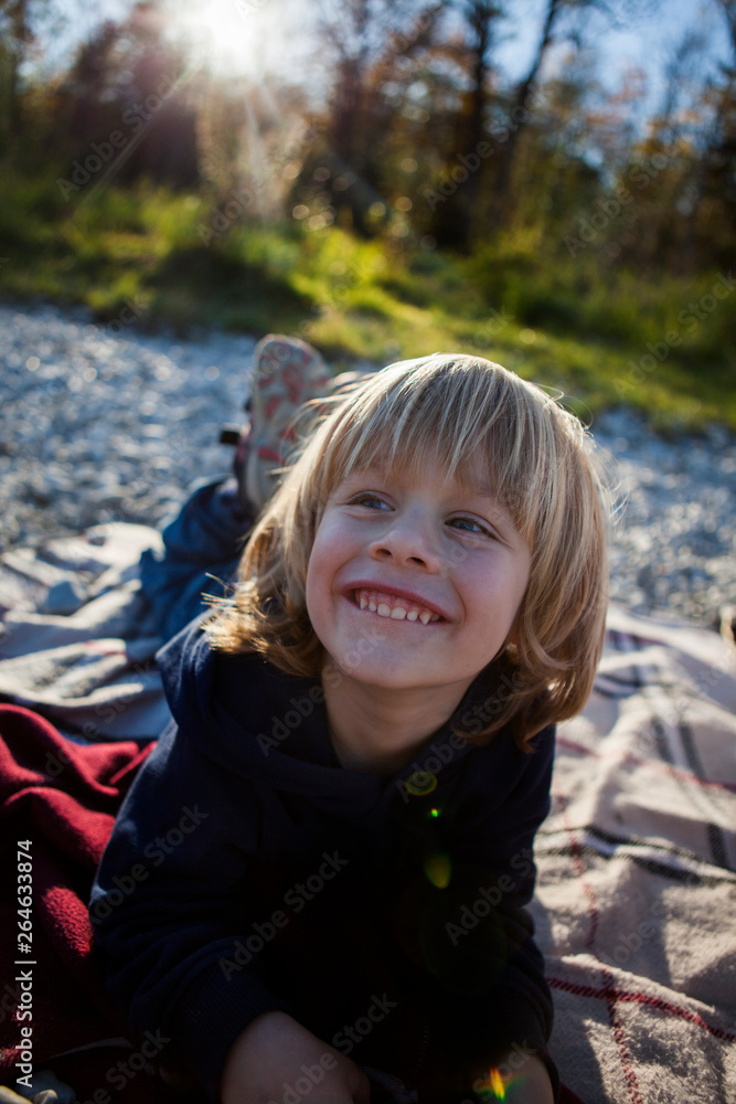 Portrait of laughing little boy lying on blanket outdoors Portrait of laughing little boy lying on blanket outdoors