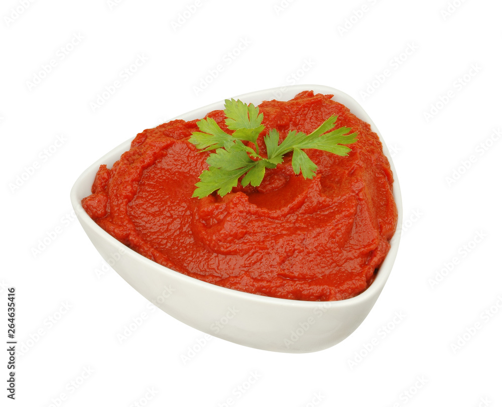 One bowl of red tomato tomato paste with parsley isolated on a white background