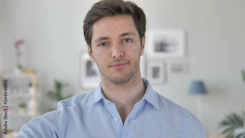 Thumbs Down by Handsome Young Man at Work, Looking at Camera Thumbs Down by Handsome Young Man at Work, Looking at Camera
