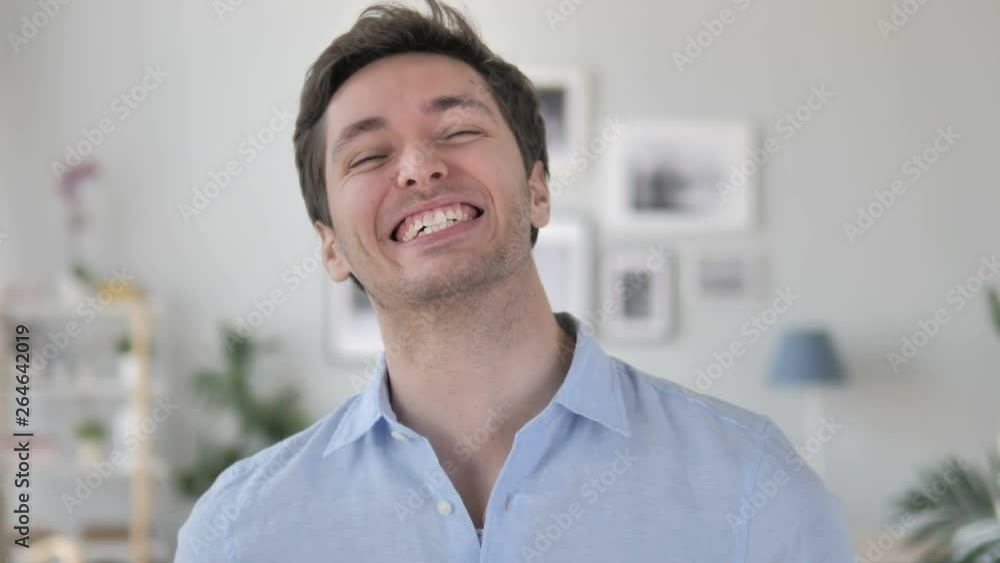 Handsome Young Man Celebrating Success Gesture in Office Handsome Young Man Celebrating Success Gesture in Office