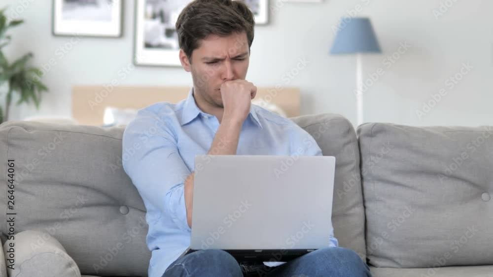 Sick Handsome Young Man Coughing while Working on Laptop at Creative Office Sick Handsome Young Man Coughing while Working on Laptop at Creative Office